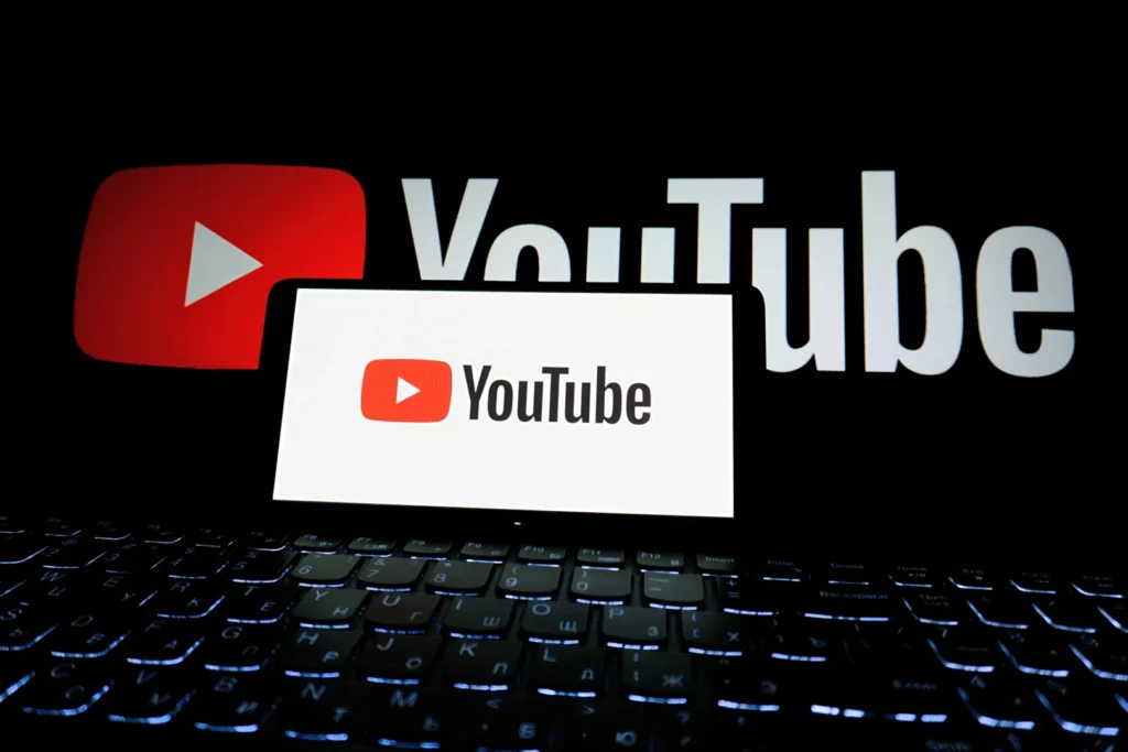 Laptop with YouTube logo representing tips on YouTube channel monetization.